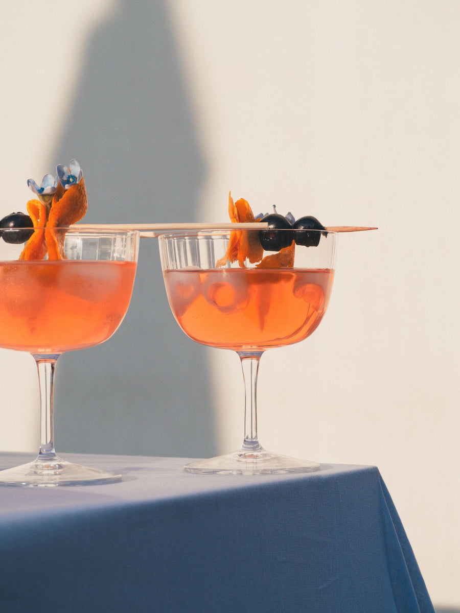 Due bicchieri eleganti di Tantan con una decorazione di fiori olive e arancia