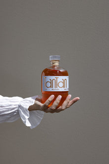 Mano che regge una bottiglia TANTAN aperitivo analcolico